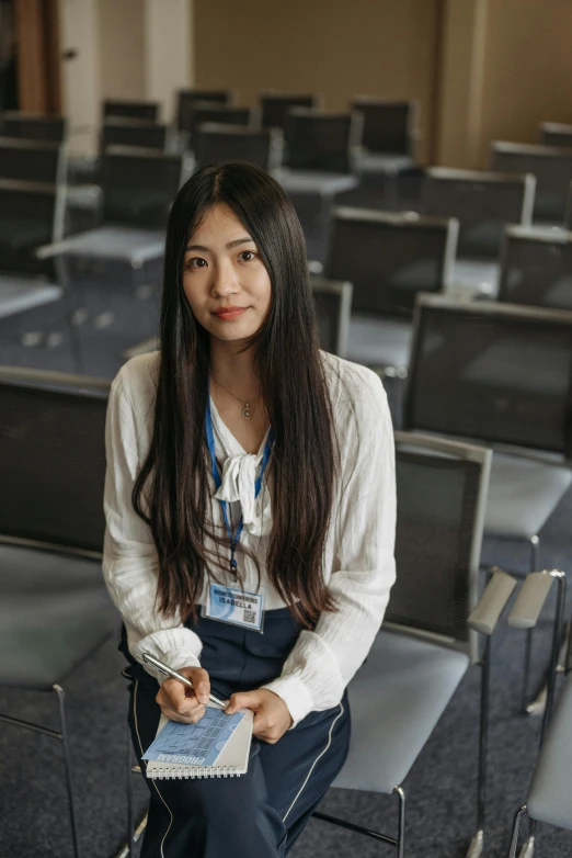 an asian female sits in a row of chairs