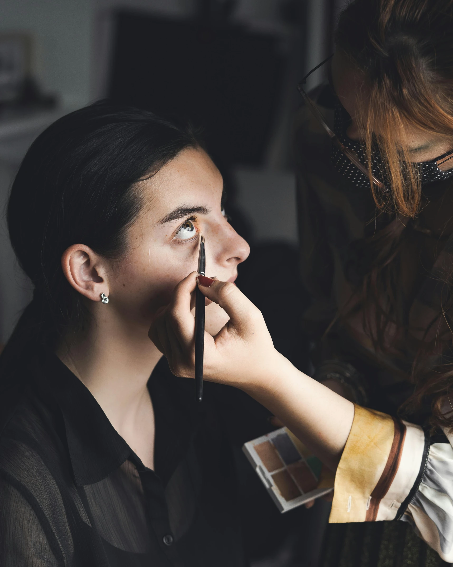 woman with eyes covered getting her makeup done