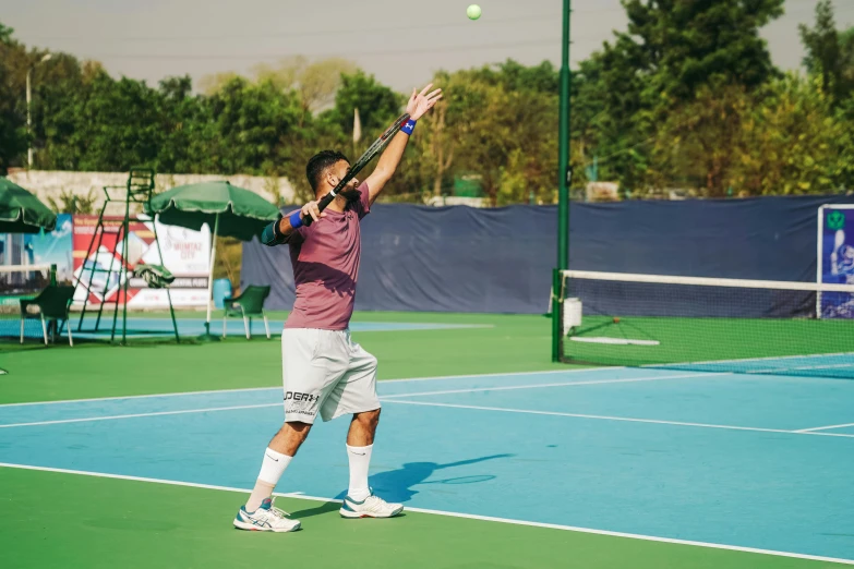 a man swinging at a tennis ball on a tennis court