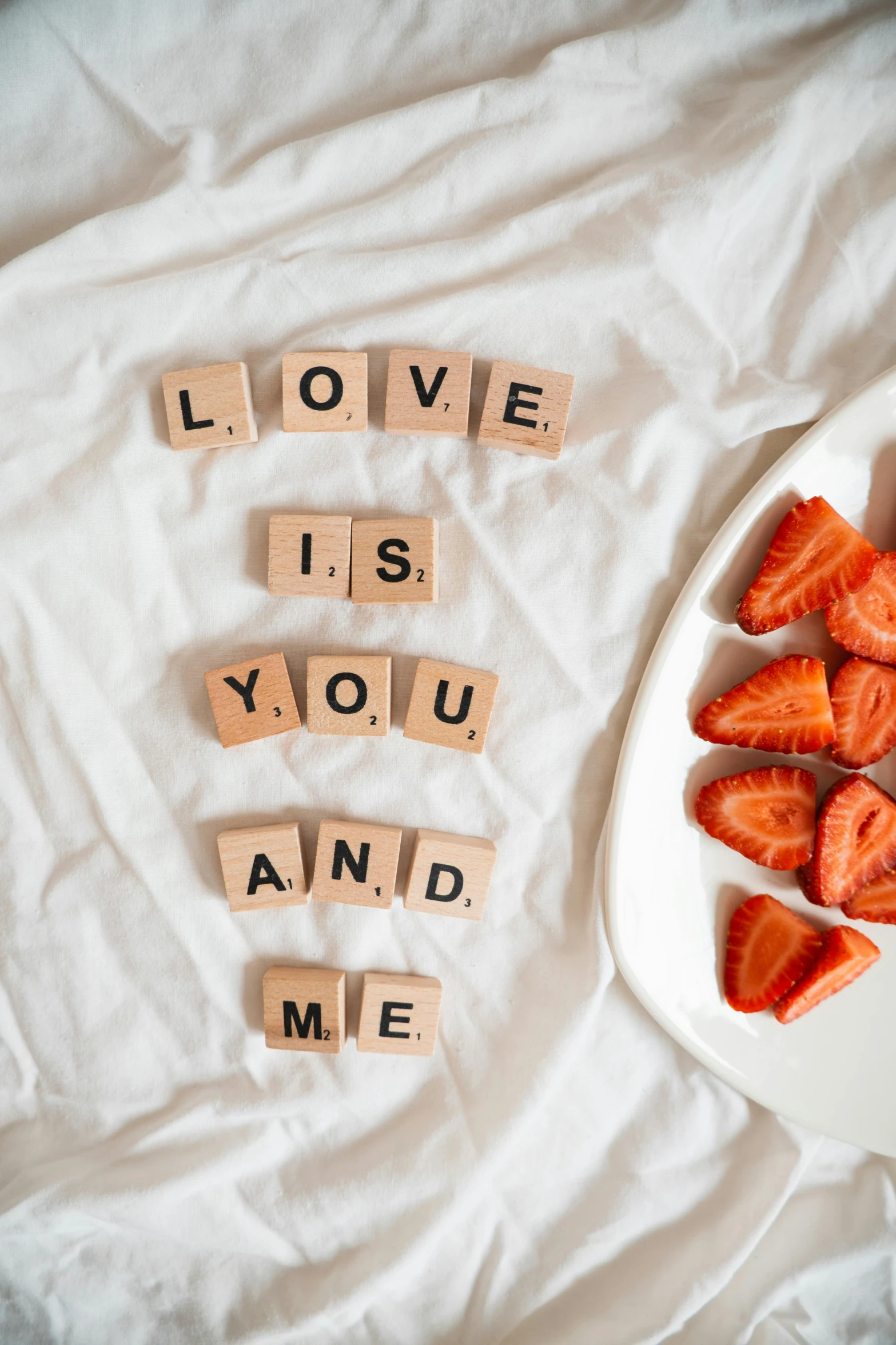 i love is you and me spelled with scrabbles on a plate