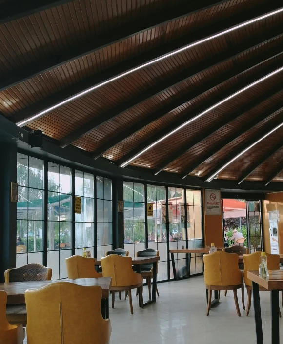 a dining area with wooden ceilings and seating