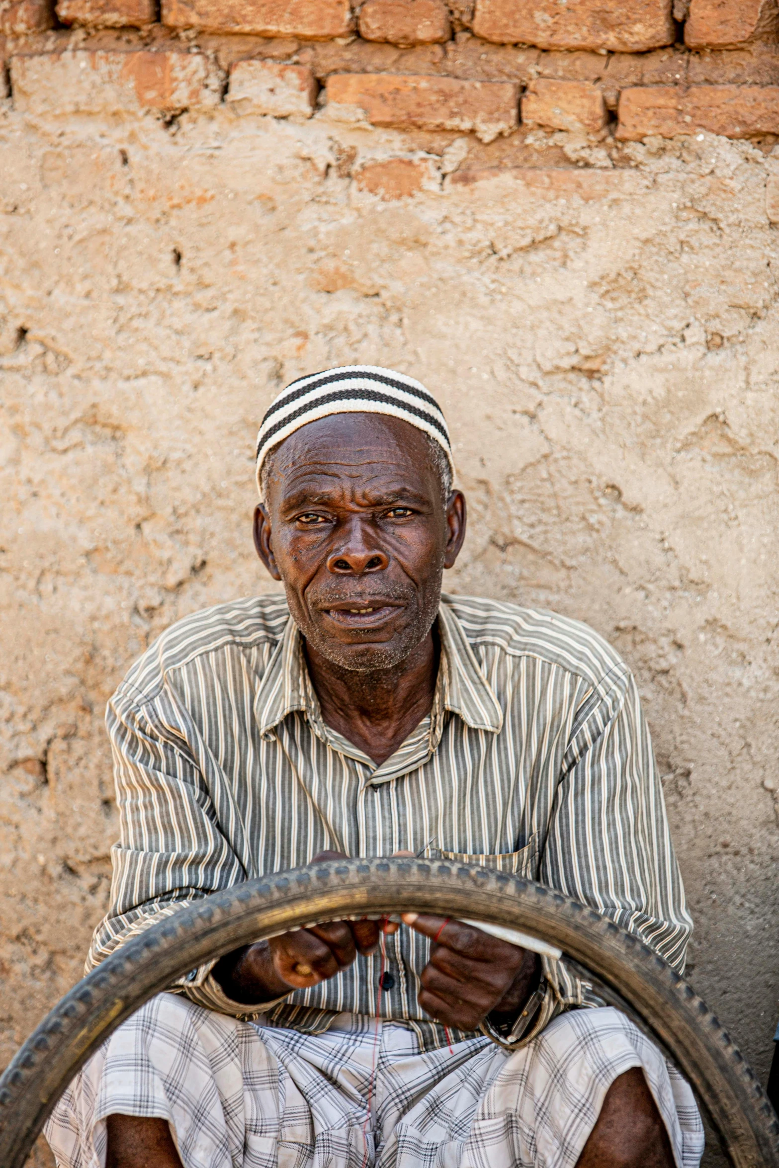 a man is sitting behind a bicycle wheel