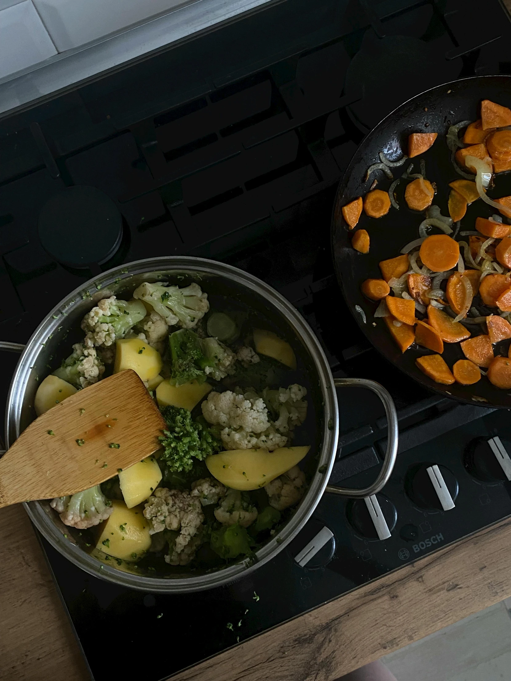 food cooking on the stove in an open pot and cooking on a wood spoon