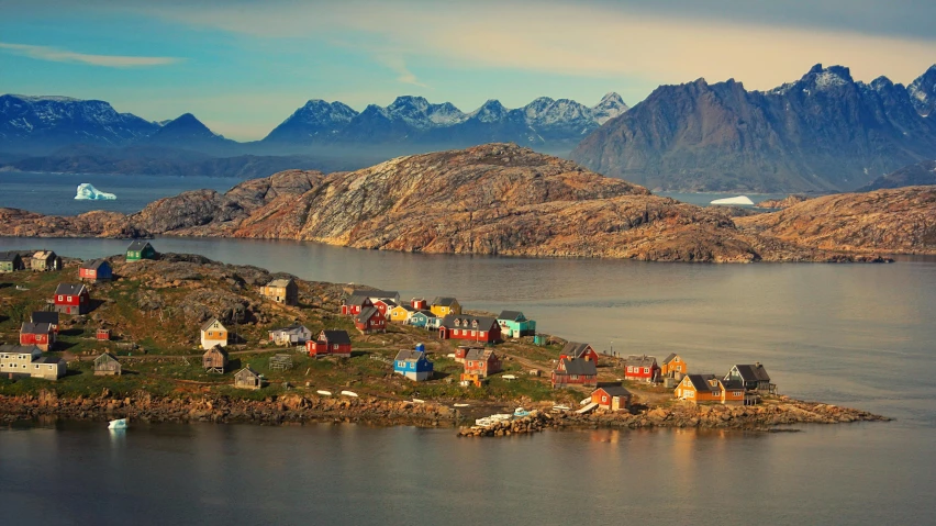 a very scenic s of some buildings with mountains in the background