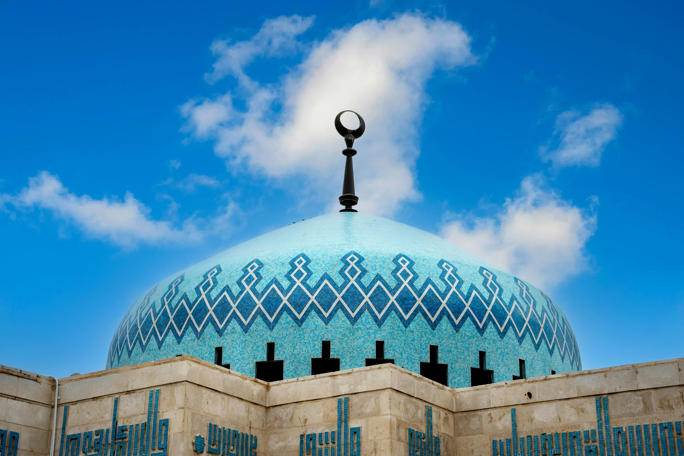 a tall blue domed building with a light post in front