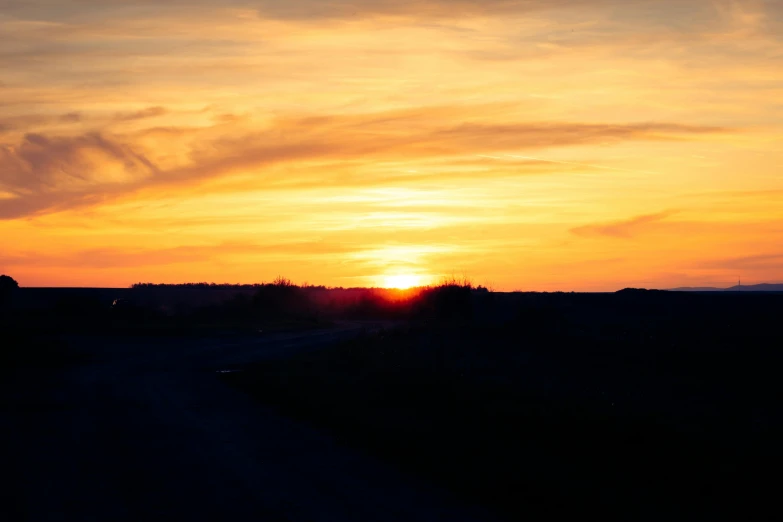 the sunset as seen from an empty field