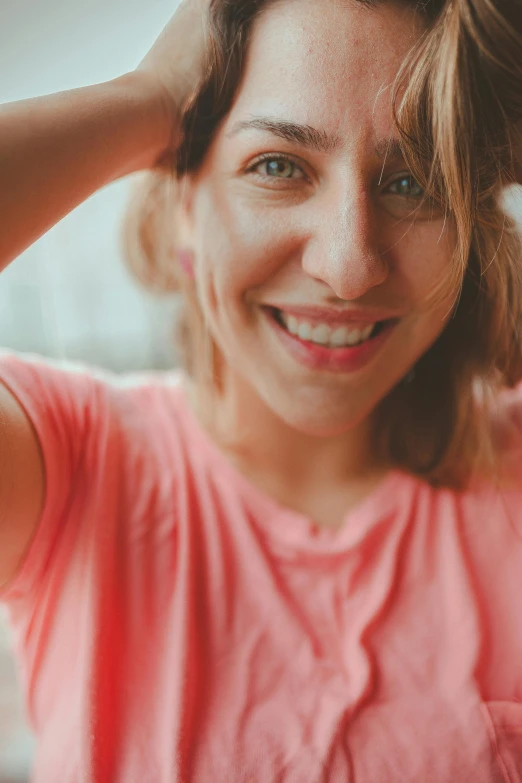 a smiling woman is putting her hair in the wind