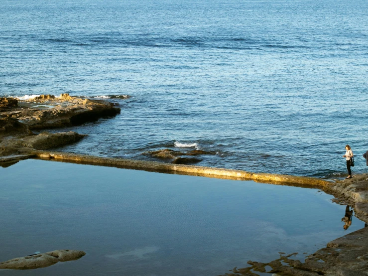 people are by a body of water looking into the distance