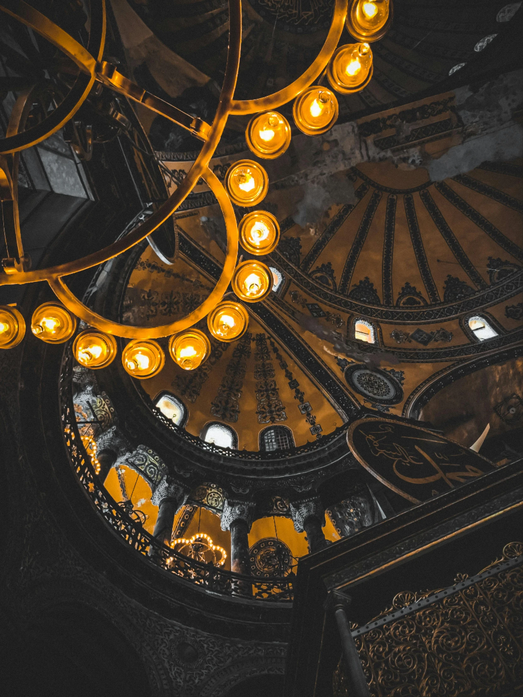 chandeliers in a stairwell lit up in the dark