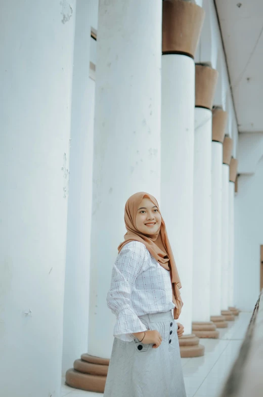 a woman in a white top is standing outside