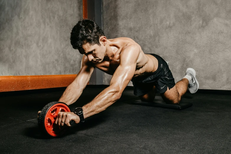 a man is performing an arm stretch with rubber wheels