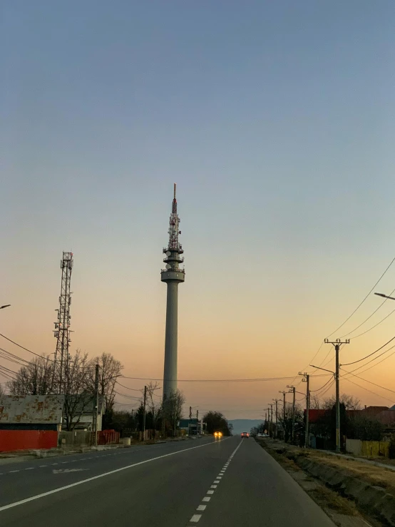 a city street with a telephone tower in the background