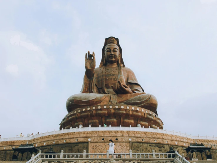 a statue is placed in front of a light blue sky