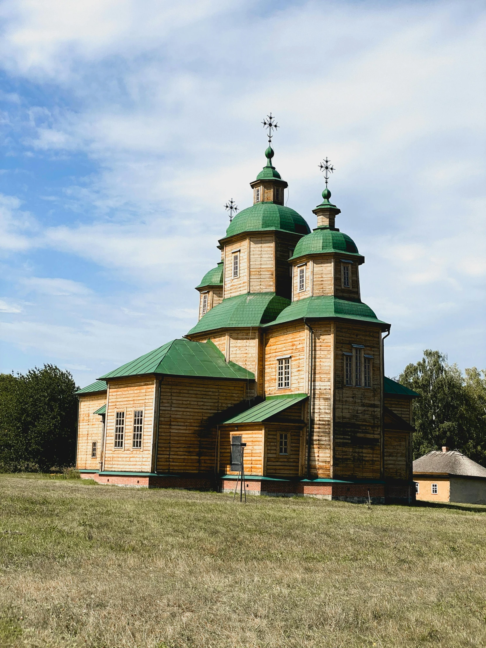 the large wooden building has green roof tops