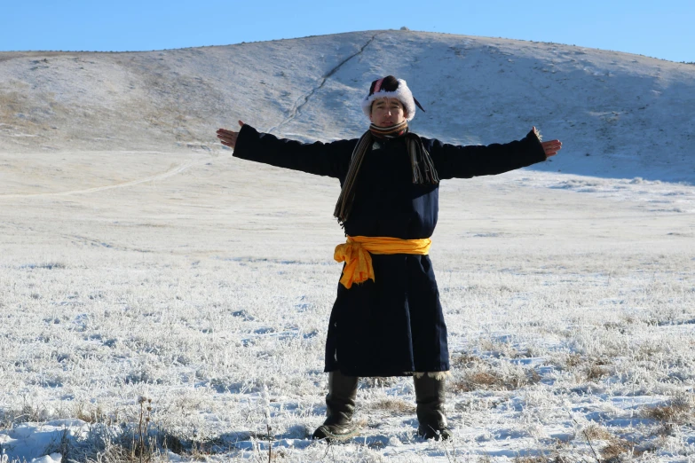 a woman is standing in the snow wearing a hat and coat