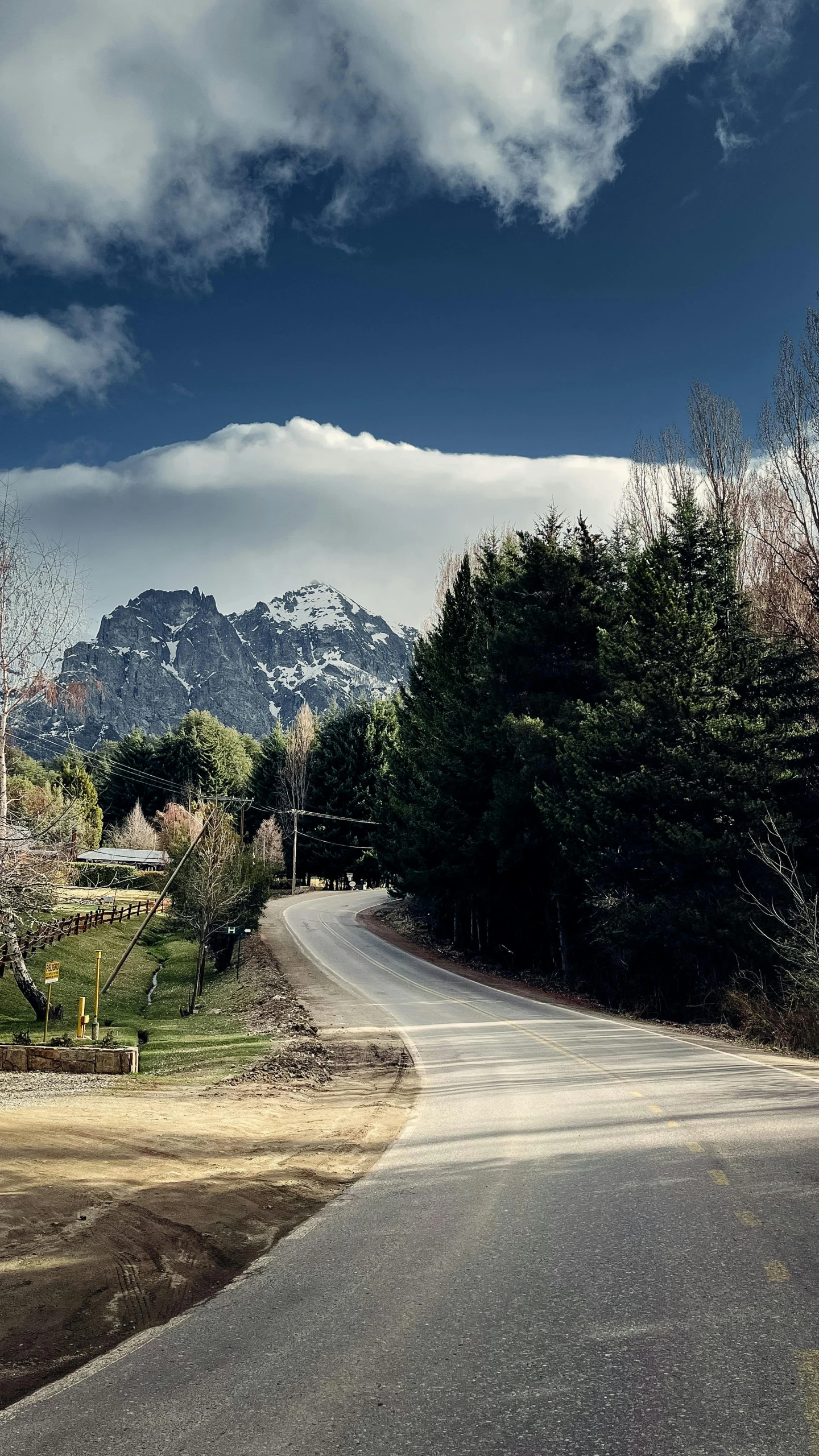 an old road running between mountains in front of some trees