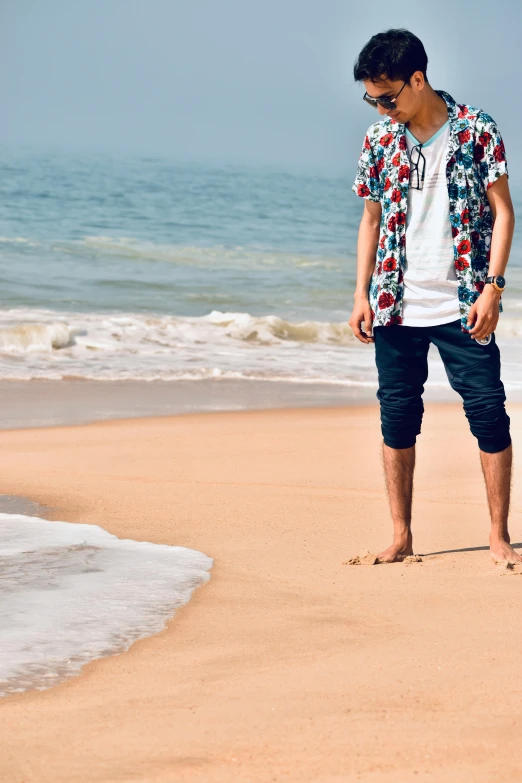 a man stands on the beach with a frisbee in his hands