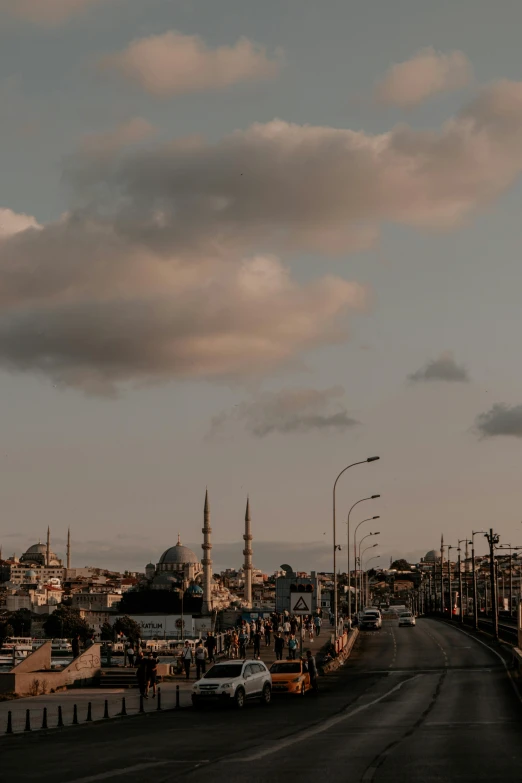 clouds are gathering over a wide street and a city