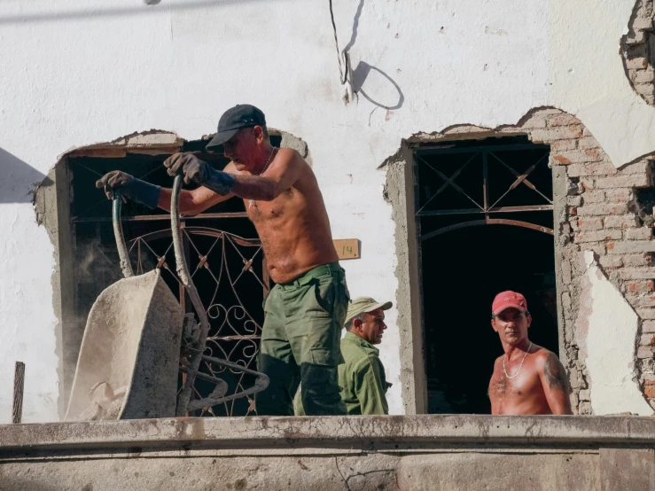 the three men are working on the hole