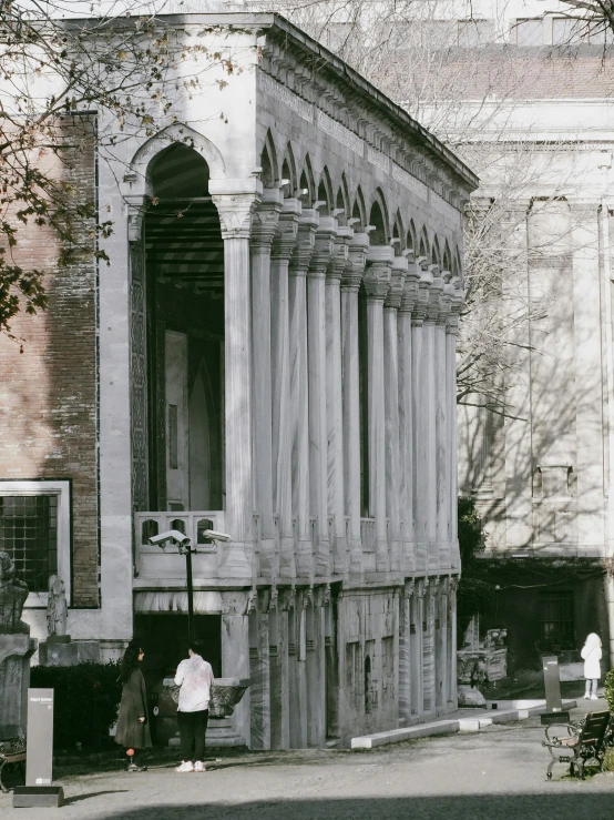 a large building with people walking on the sidewalk