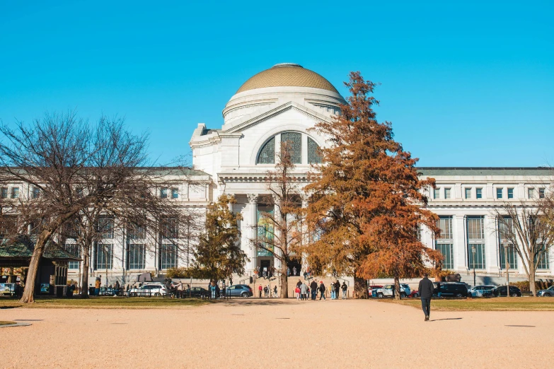 a domed building sits in the middle of an empty park