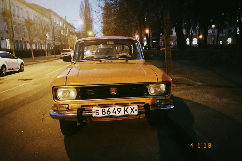 the old car is parked on the street at night