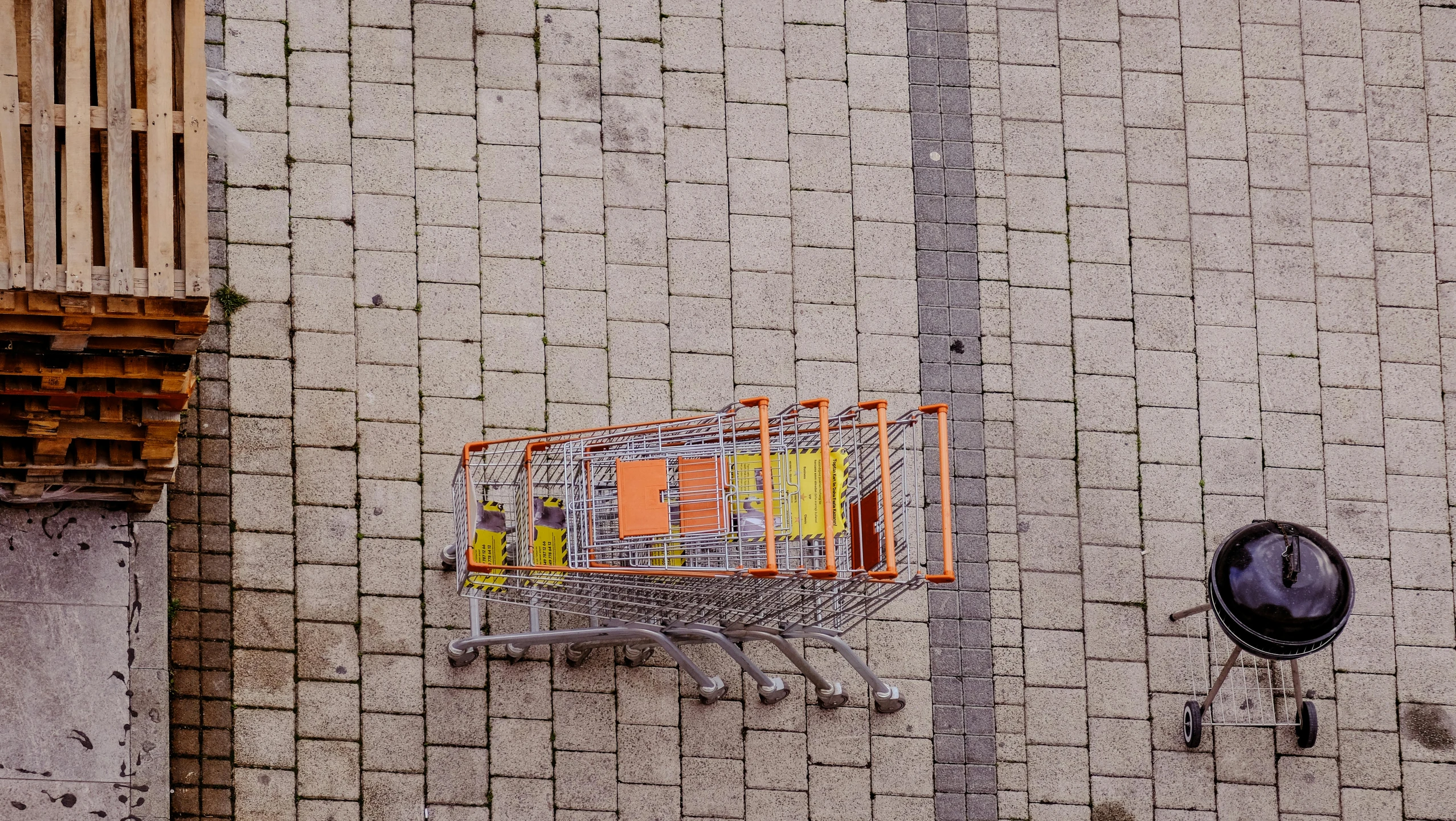 a shopping cart is hanging on a brick wall