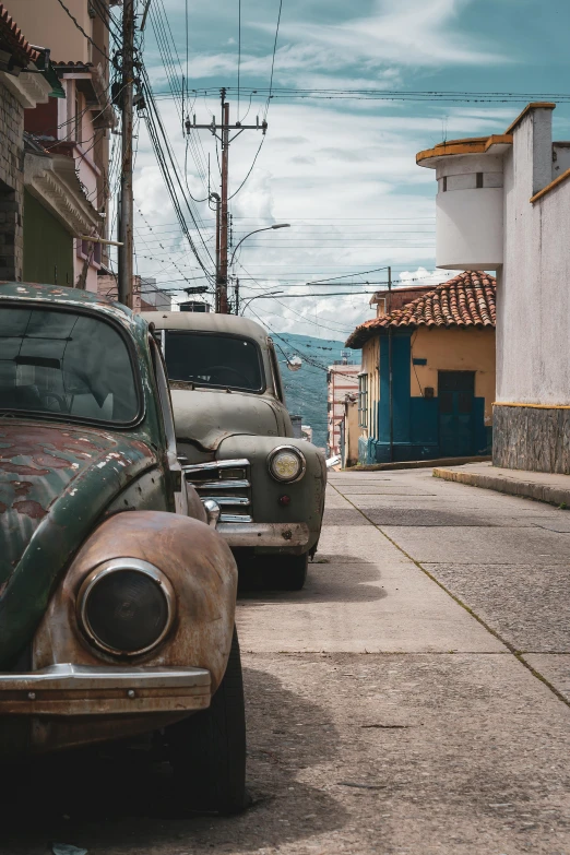 old car parked on a street in small town