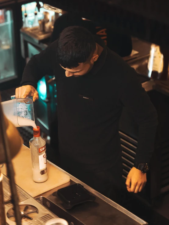 a man standing in a bar pouring soing out