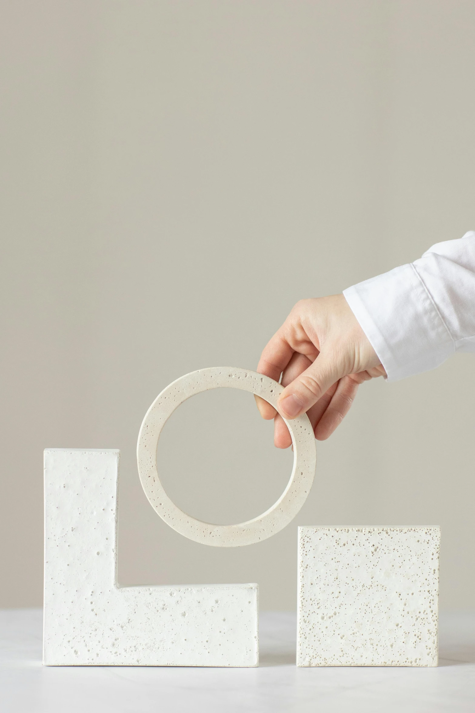 a hand is holding soing with one finger in a sculpture made of small squares