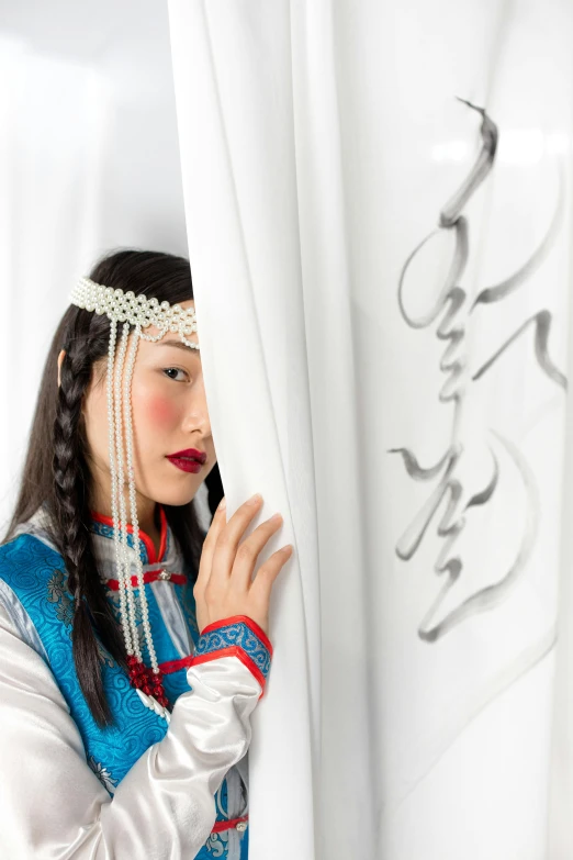 an oriental woman hides behind a curtain and looks over