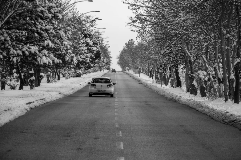 a car driving down the middle of an empty road