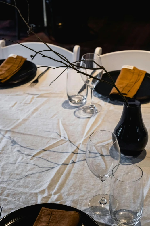 a plate with a candle holder on it near wine glasses