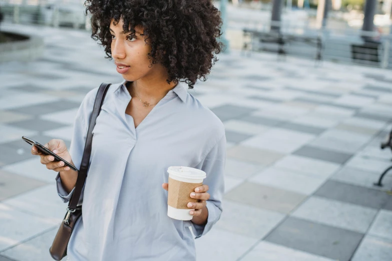 a woman walking while looking at her phone