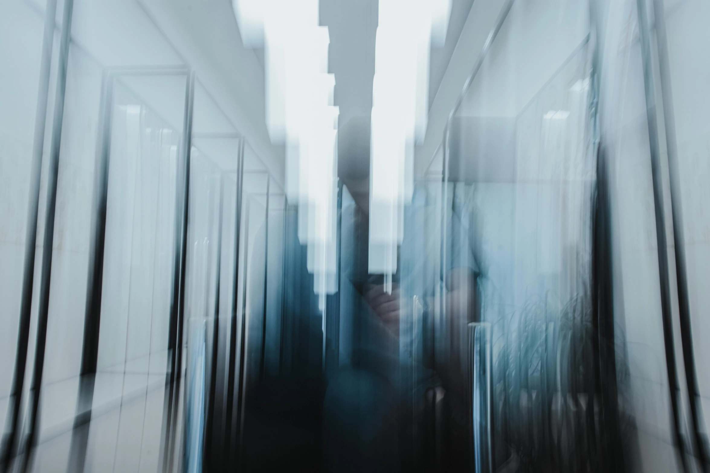 person walking through long corridor in blurry po