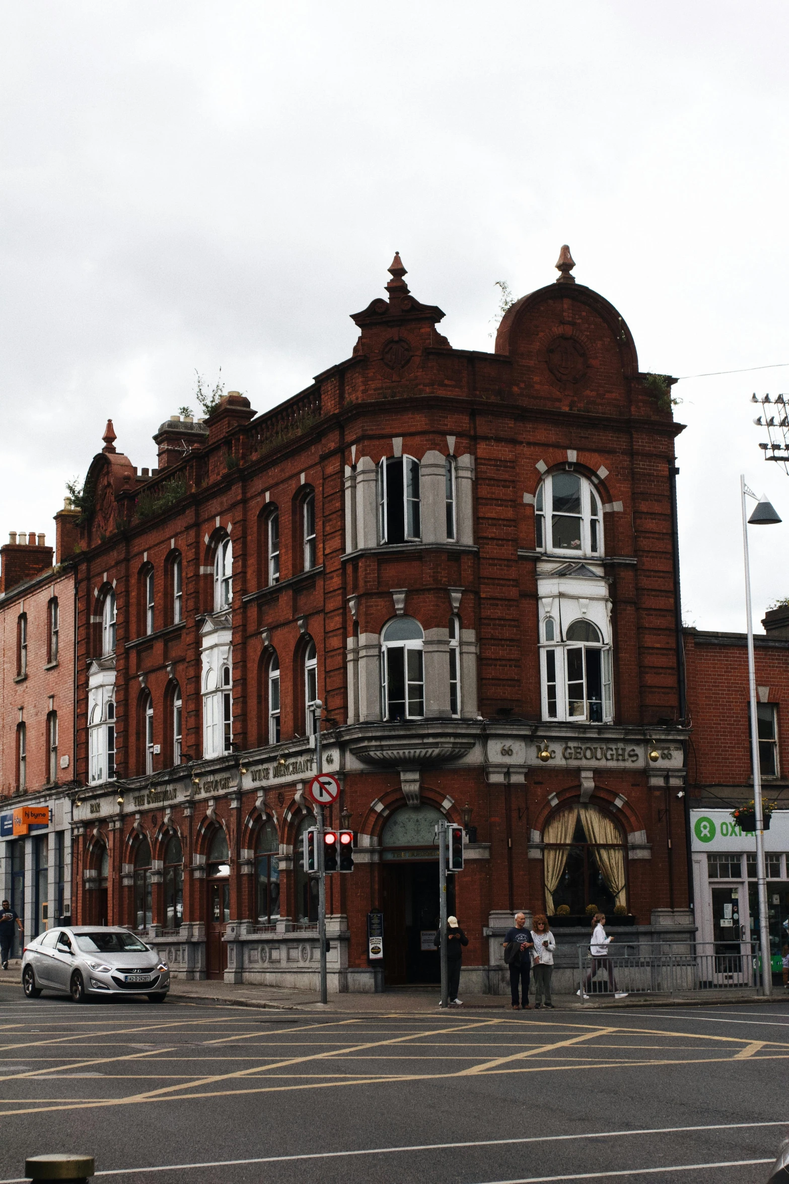 a street corner with buildings and pedestrians walking by