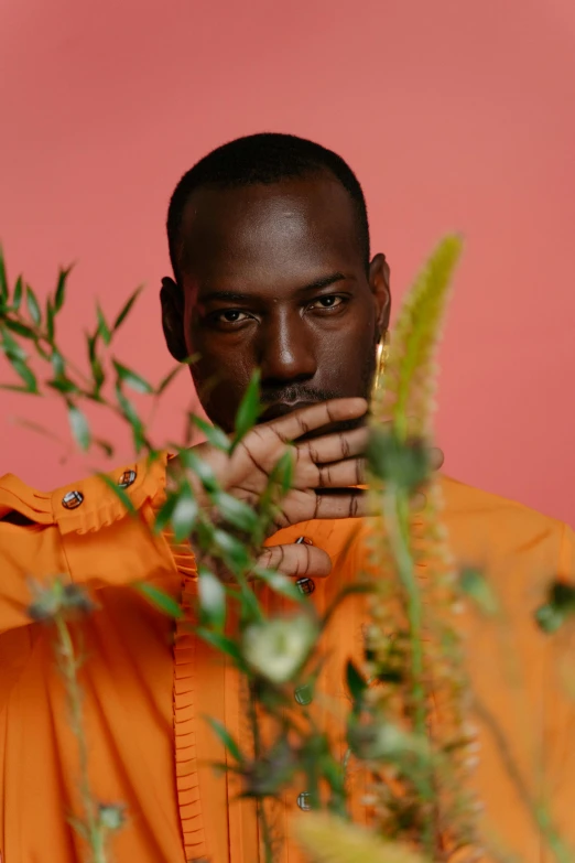 man in an orange shirt looking over the camera