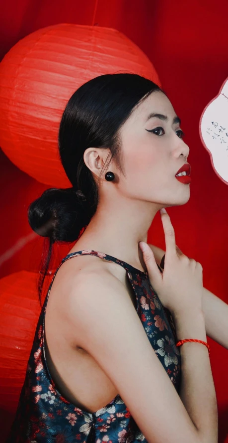 an asian woman in an oriental dress holding her hands against her face