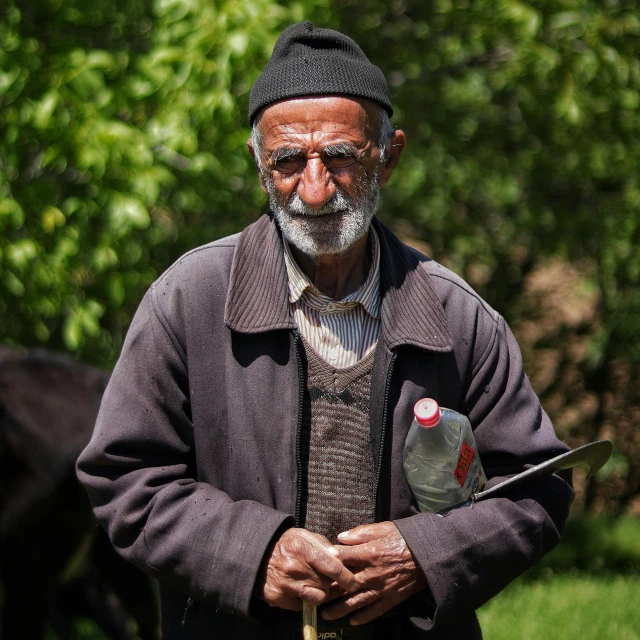 a man with a bird in his hand standing near trees