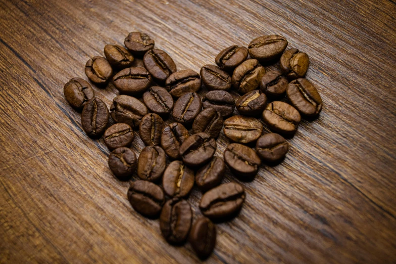 the wood table has lots of dark coffee beans