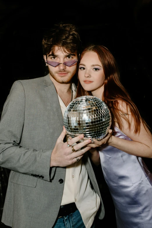 two people in costume posing with a disco ball