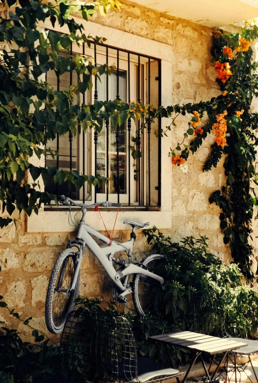 a bicycle sitting on a stone building next to a window