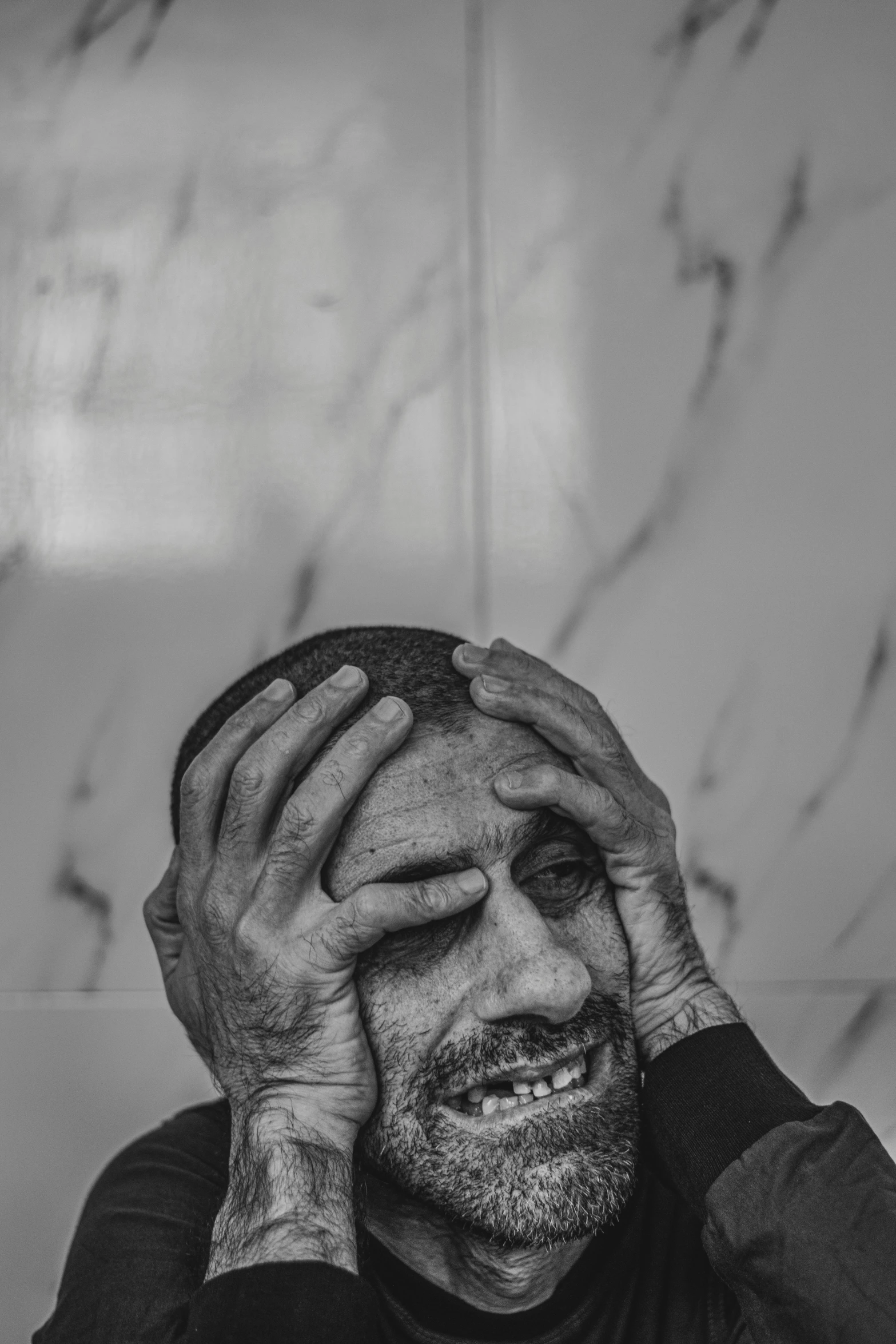 black and white pograph of a man covering his eyes