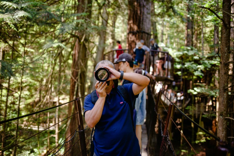 the person in the blue shirt is looking through his binoculars