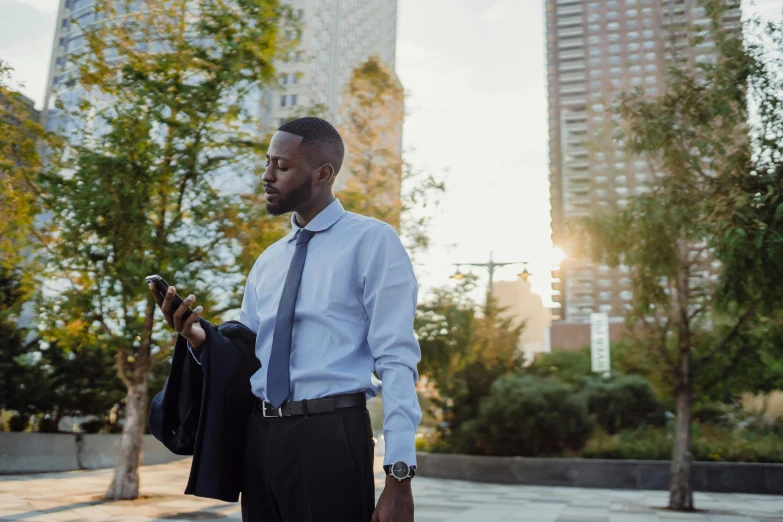 man walking in the sun holding a suit case