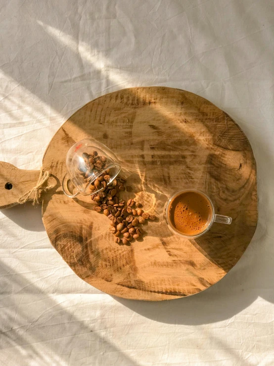 a tea tray sitting on a bed with a glass of coffee next to it