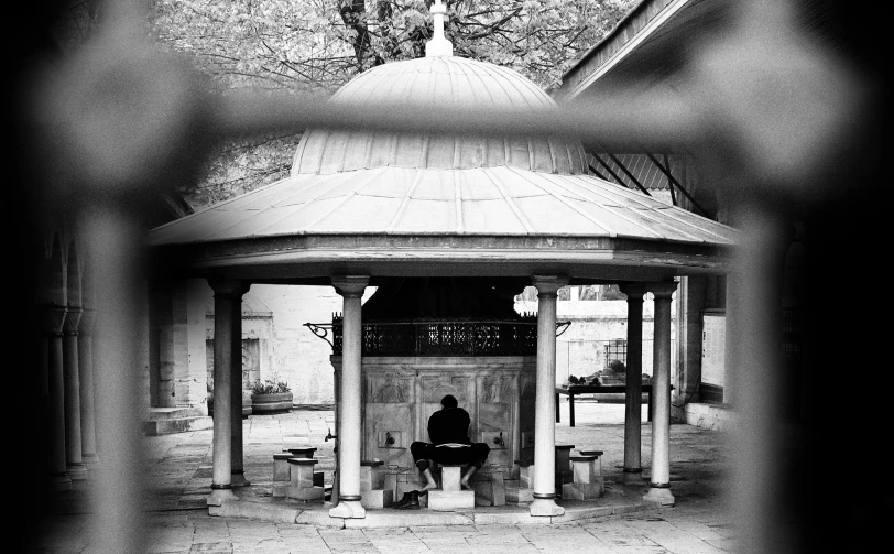 a man in a hat sitting on a bench