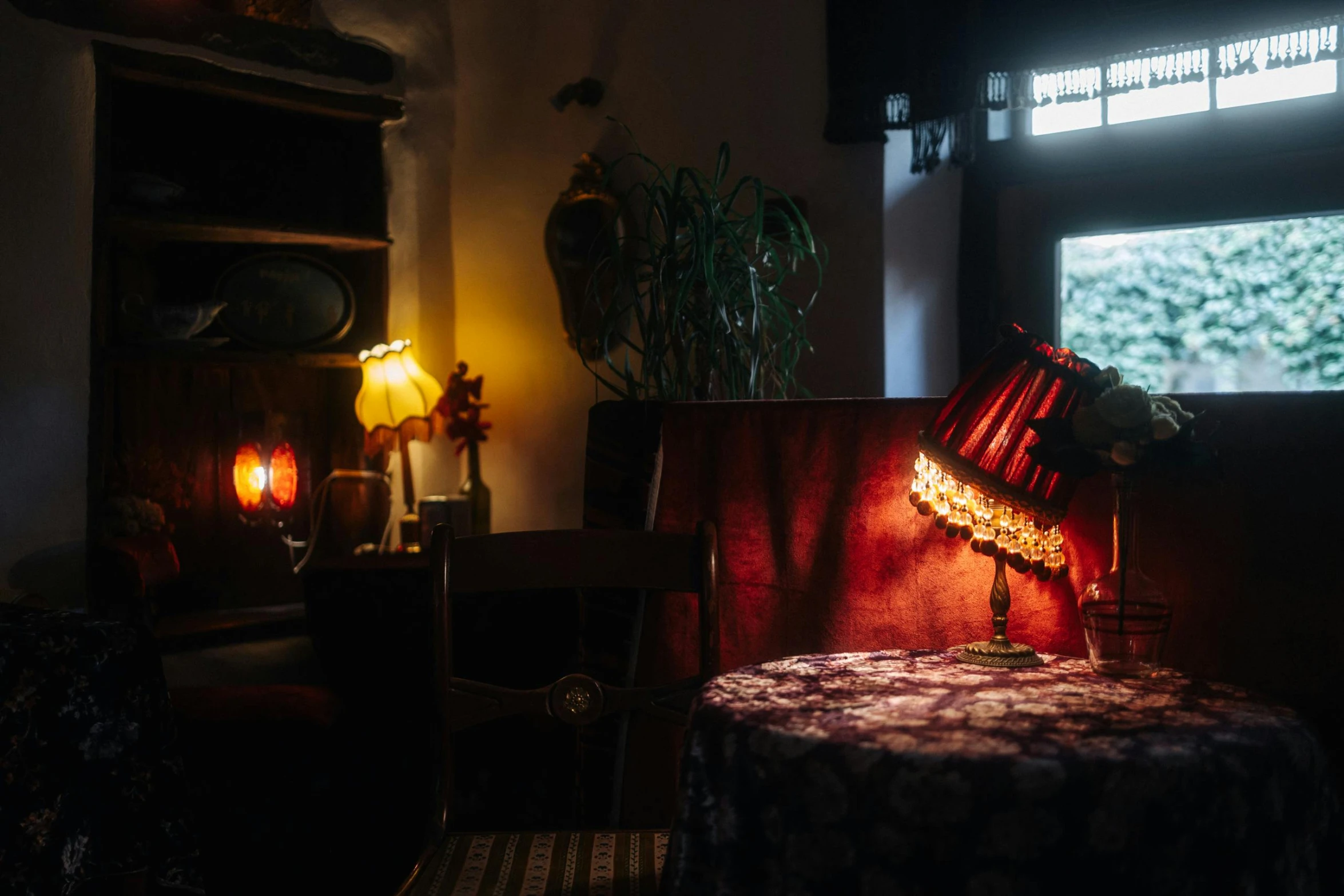 an illuminated room with a chair and small table