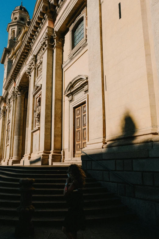 a person standing near the steps next to a building