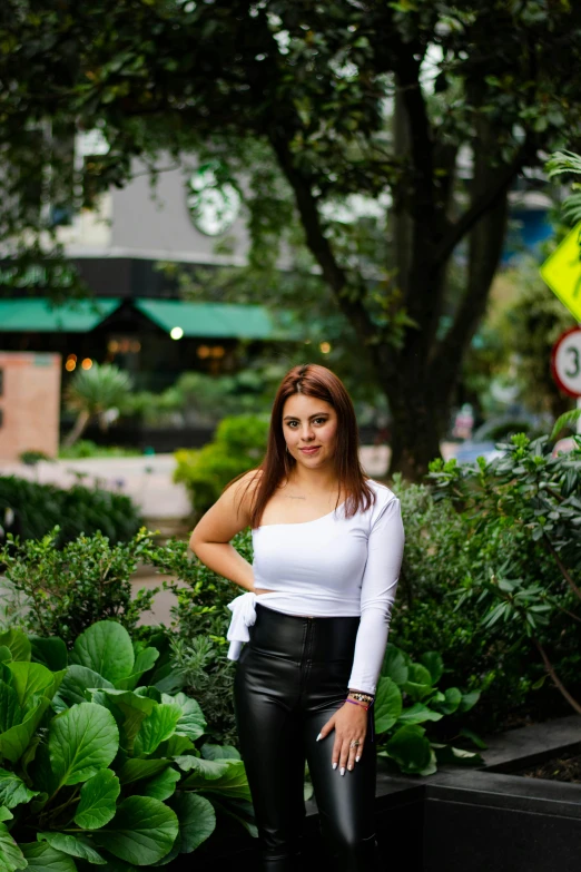 woman in white shirt and black pants standing in park